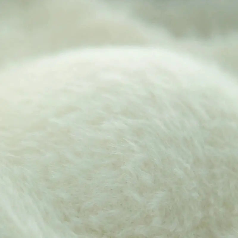 Plush white fleece fabric close-up showing soft faux fur texture and cozy warmth