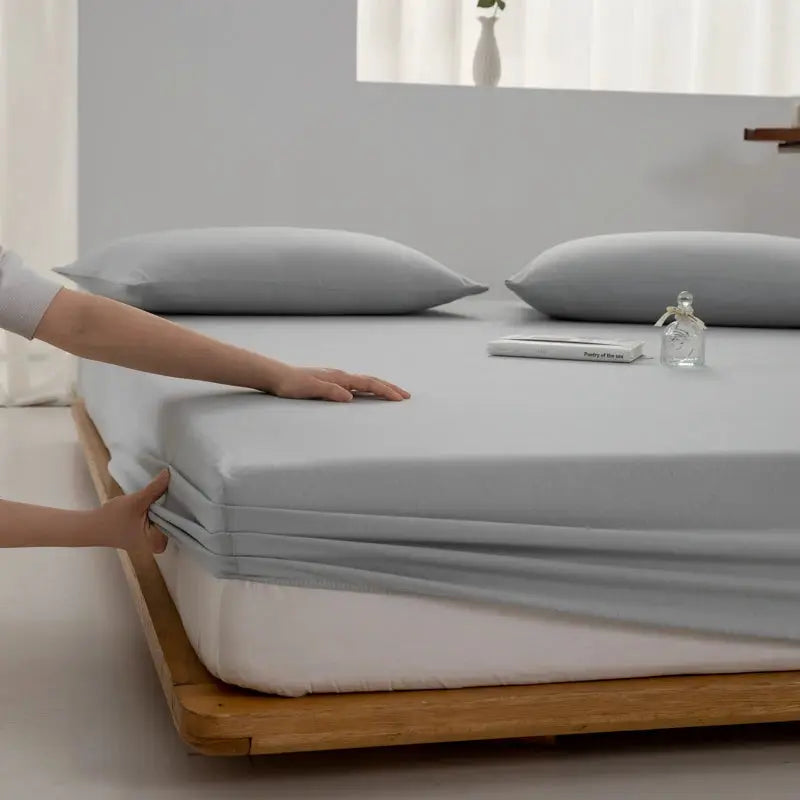 Simples Market soft cotton fitted sheet in light gray with elastic corners on a wooden bed frame