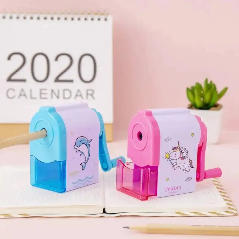 Two plastic mechanical pencil sharpeners in blue dolphin and pink unicorn designs with transparent reservoirs