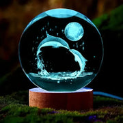 3D Dolphin Moon crystal ball lamp by Simples Market with blue glow on wooden base