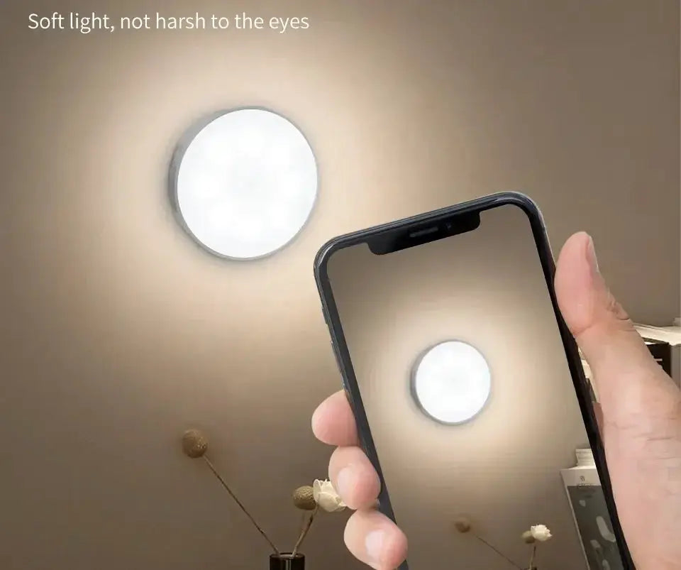 Round white LED night light mounted on wall; USB rechargeable, shown on smartphone screen