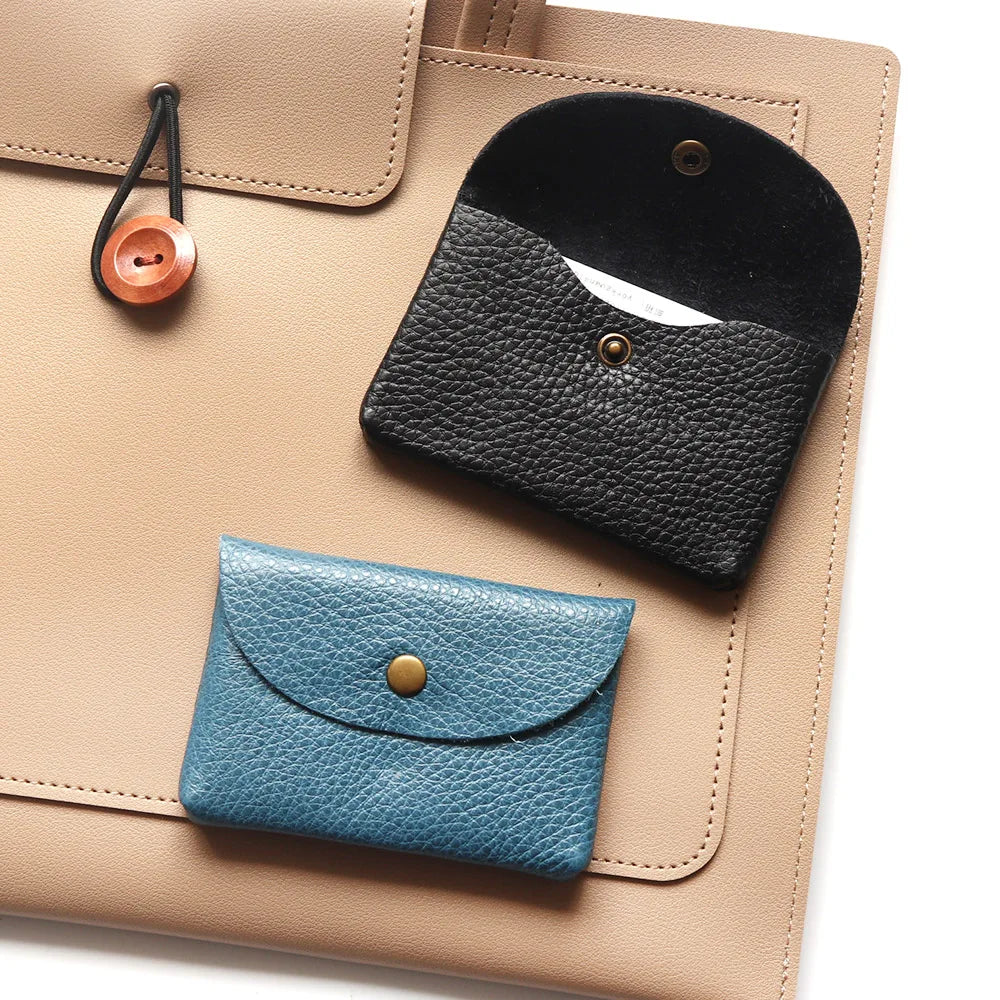 Genuine leather card holders in blue and black on a beige organizer; compact mini envelopes.