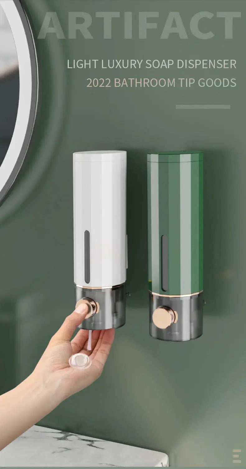 Manual wall-mounted soap dispenser pair; white and green finishes with rose-gold pumps.