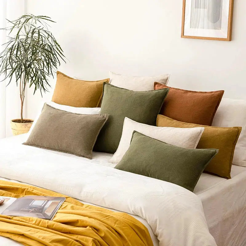 Decorative ramie cushion covers set on white sofa in boho farmhouse style; mustard, olive, taupe and cream cushions.