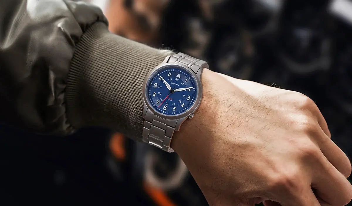 BERNY titanium men's field watch with blue dial on a metal bracelet.