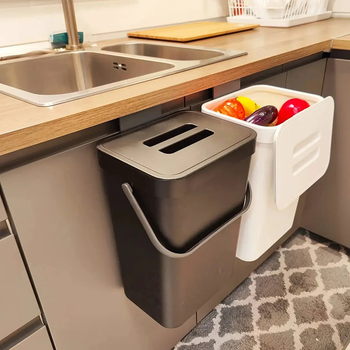 Space-Saving Quiet-Close Trash Can (3/5L) in black mounted on kitchen cabinet beside white produce bin.