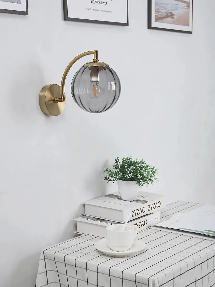 Modern LED wall lamp with glass globe shade and brass finish by Simples Market