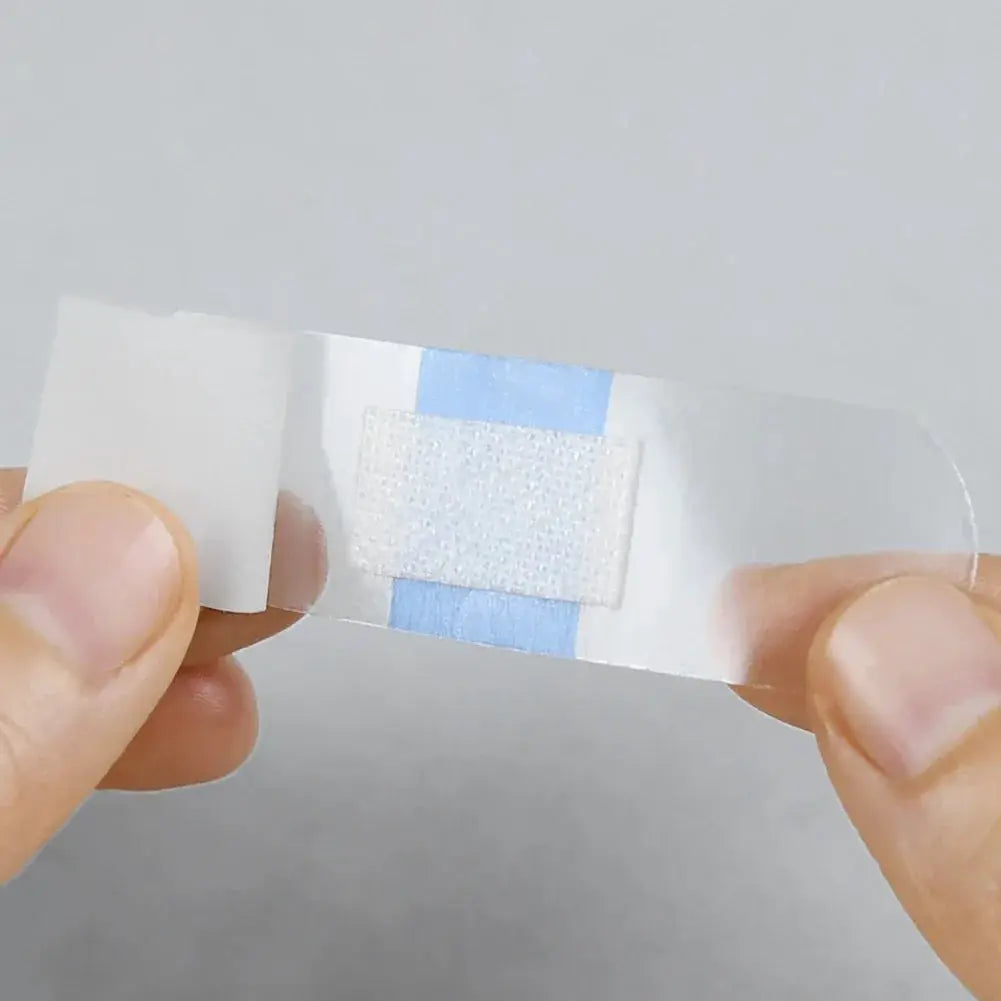 Transparent waterproof adhesive wound plaster with blue edges and white central pad