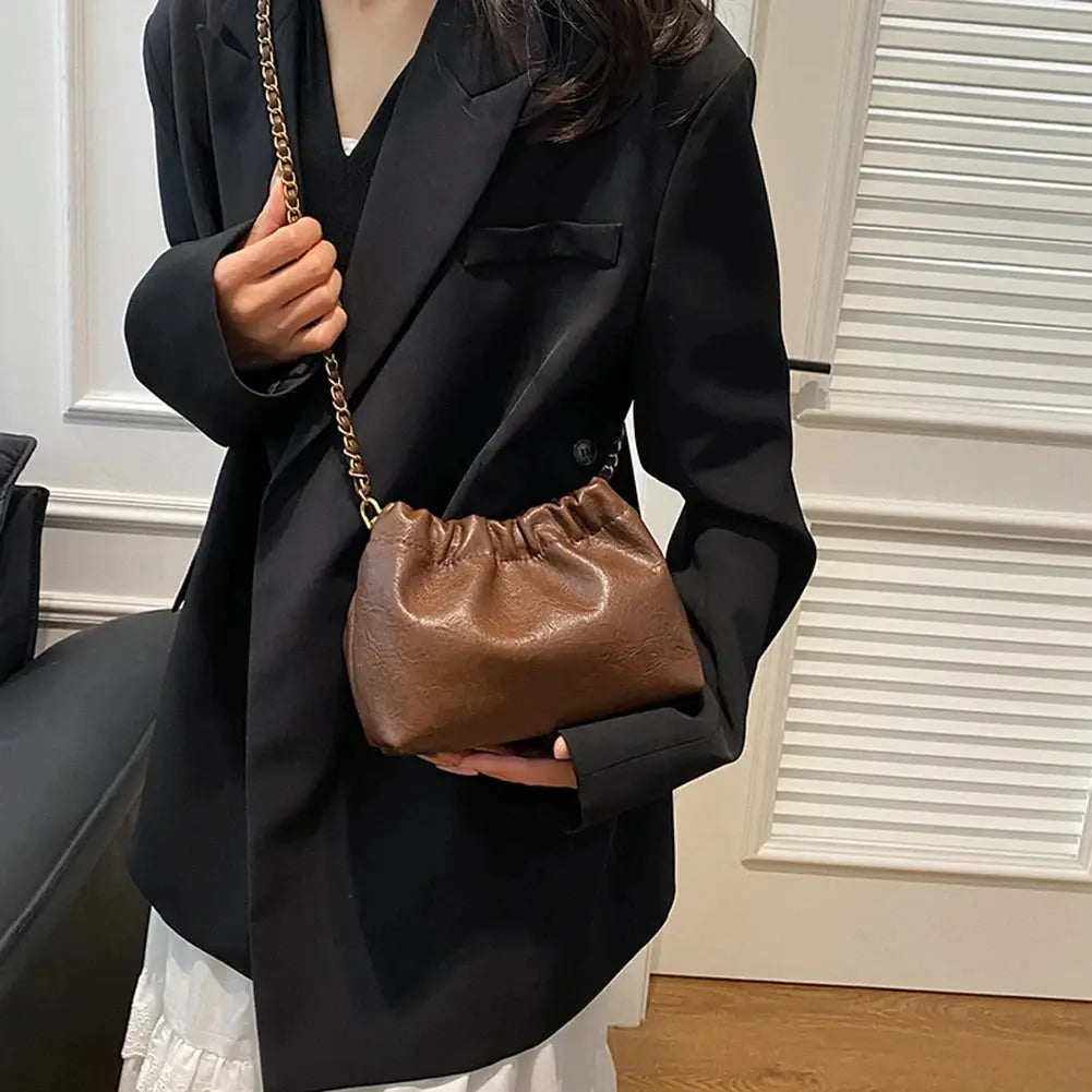 Women’s chain-strap shoulder bag in brown leather with gathered top for versatile crossbody or handbag use