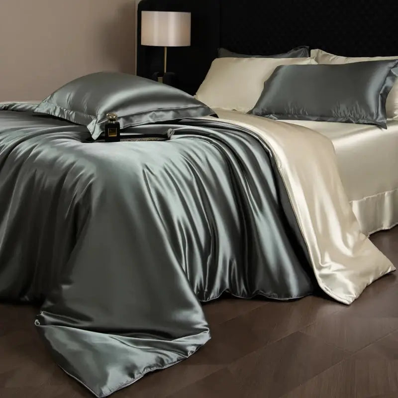 Silk bed sheet set by Simples Market in silver-gray satin with ivory duvet cover and pillowcases