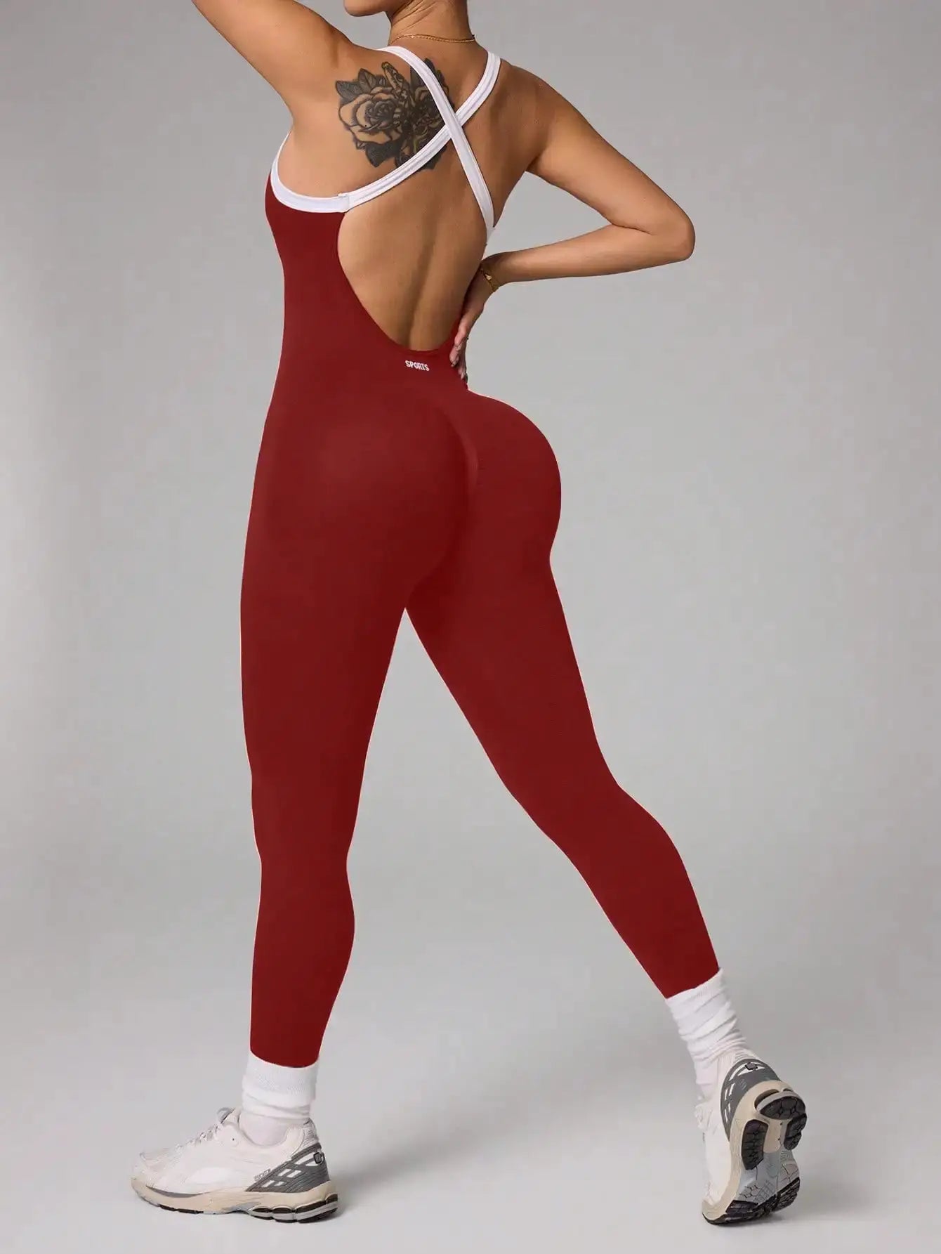 Red seamless cross-back yoga jumpsuit with white trim for full-length fitness training.