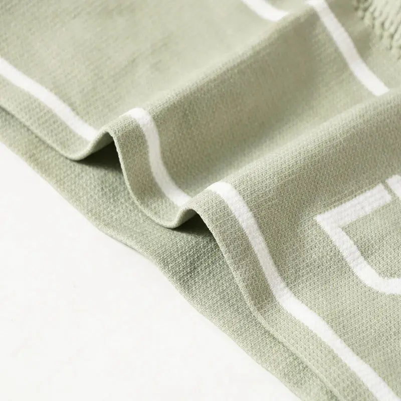 Women's bra fabric close-up in sage green with white piping