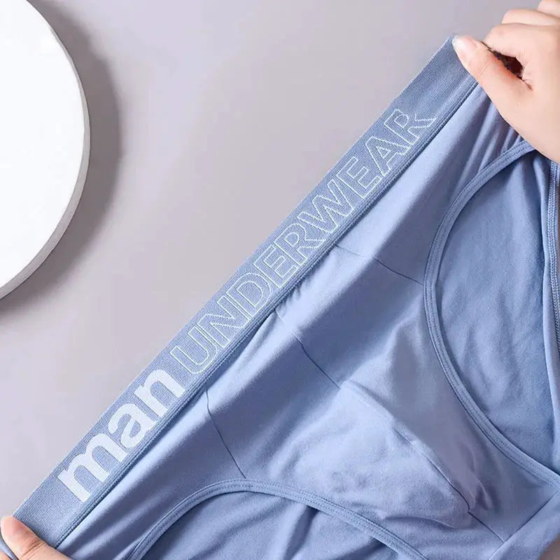 Light blue men's briefs with a branded waistband reading MAN UNDERWEAR.
