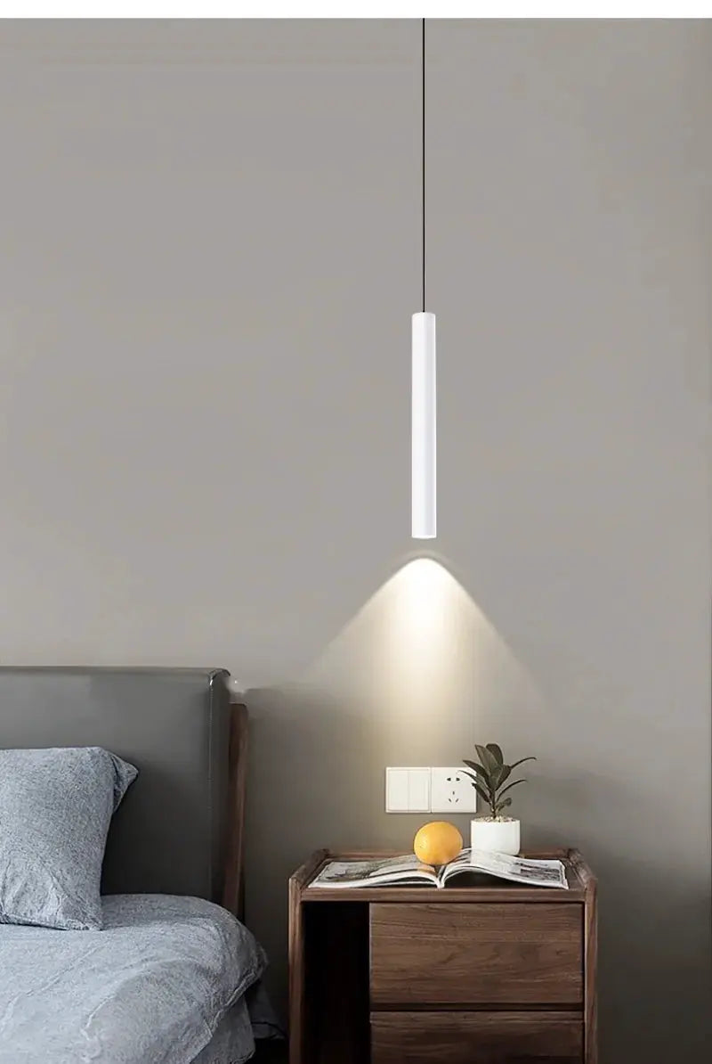 Minimalist bedside pendant lamp by Simples Market, white cylindrical LED hanging light over a wooden nightstand