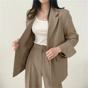 Beige two-piece women's suit: blazer with wide-leg pants worn over a white top