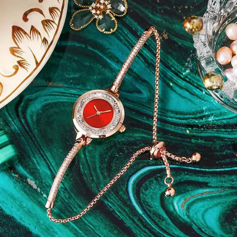 Wristwatch with gold-tone bracelet, red dial and crystal-studded bezel