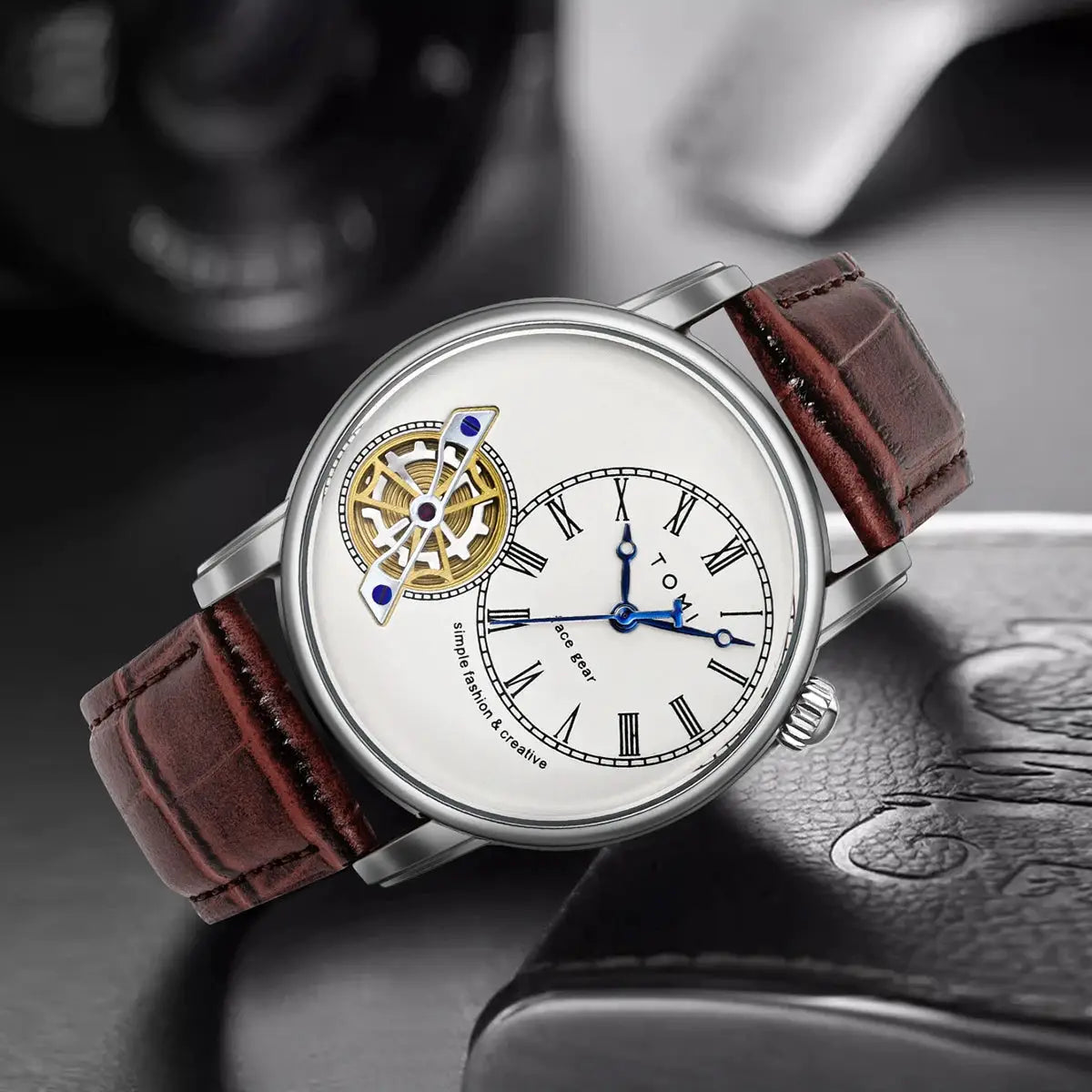 TOMI men's wristwatch with brown leather strap, white dial, Roman numerals, blue hands, exposed mechanism