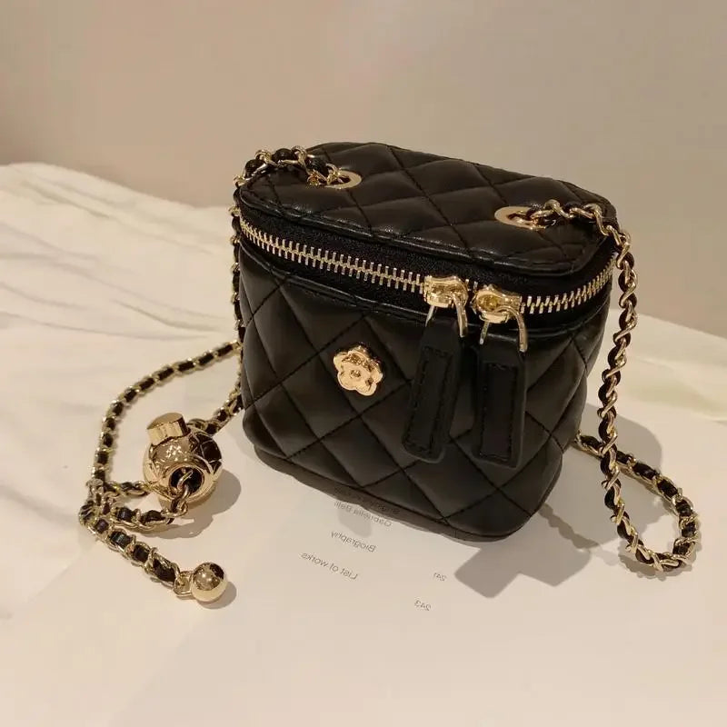 Simples Market Camellia quilted mini shoulder bag in black with gold chain strap.