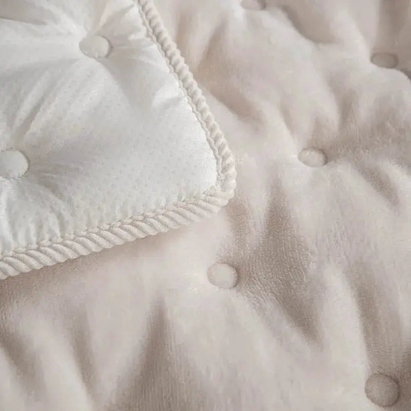 Sofa cushion in cream flannel with tufted dots and braided trim.