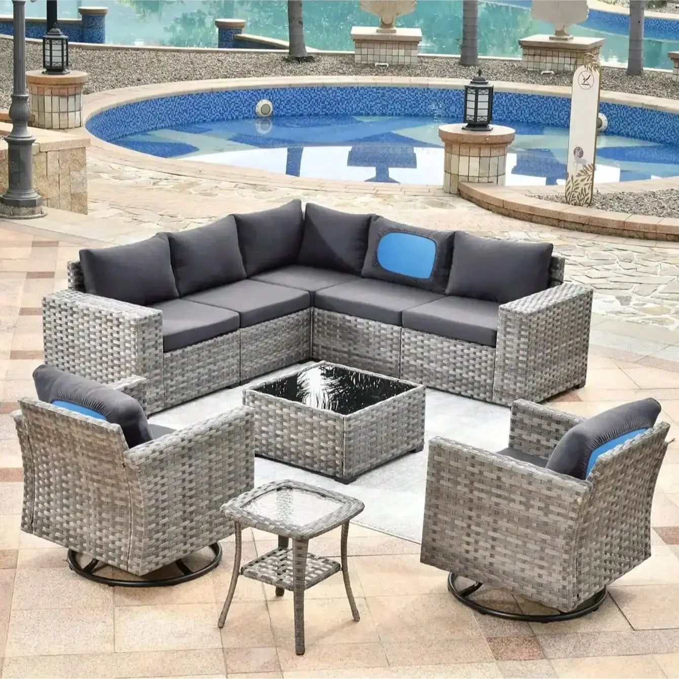 Outdoor wicker sectional sofa with gray cushions and blue accent pillows on a poolside patio.