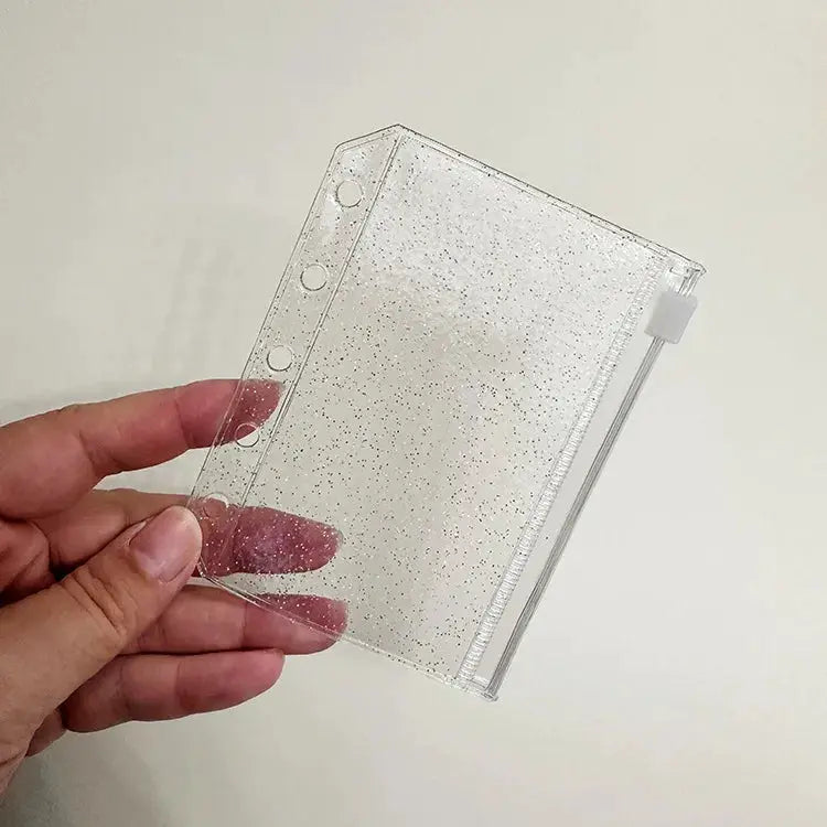 Clear glitter PVC binder pocket with 6-ring holes and zipper closure for 6-ring notebooks.