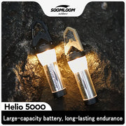 Soomloom Helio 5000 camping lanterns, 2-pack with 5000mAh battery, silver bodies and black/tan handles, lit on rocky terrain