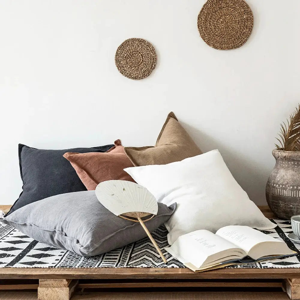 Decorative ramie cushion covers, 5-piece boho farmhouse set in gray, navy, white, beige, rust on a wooden bench