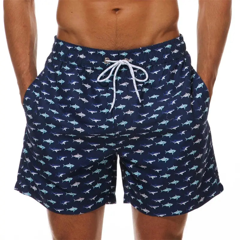 Men's navy swim shorts with allover light blue fish print, white drawstring waist, side pockets