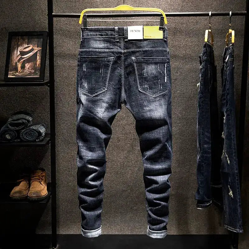 American Elastic Straight Jeans; distressed blue-black denim with back pockets and rolled cuffs, three pairs on display