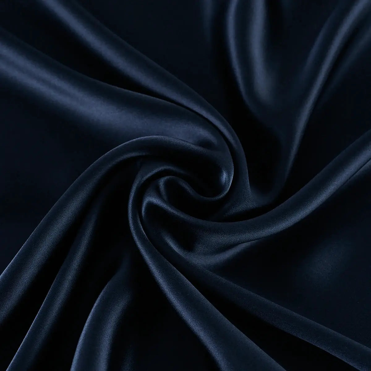 Silk pillowcase in navy blue with smooth draped folds and satin sheen