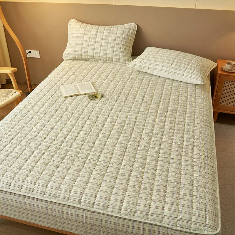 Simples Market quilted plaid mattress protector with antibacterial breathable fabric in beige plaid on bed