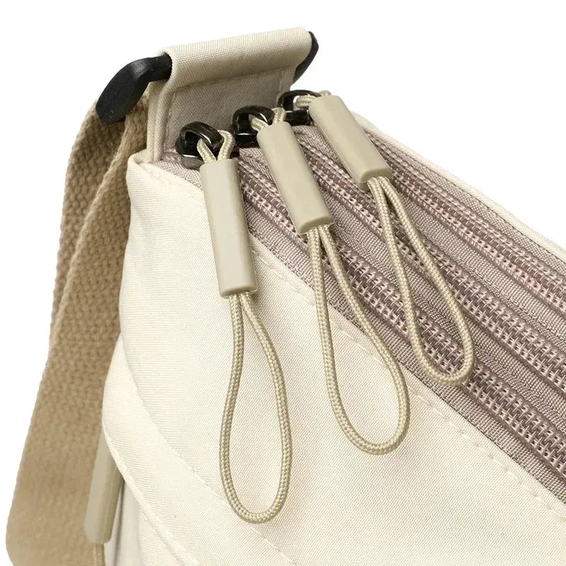 Canvas crossbody bag with three main pockets, beige color, shoulder strap