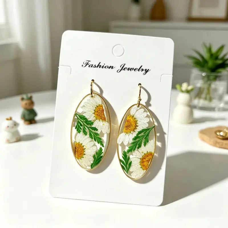 Pressed flower epoxy resin earrings in gold oval frames with white daisies and green leaves (pair)