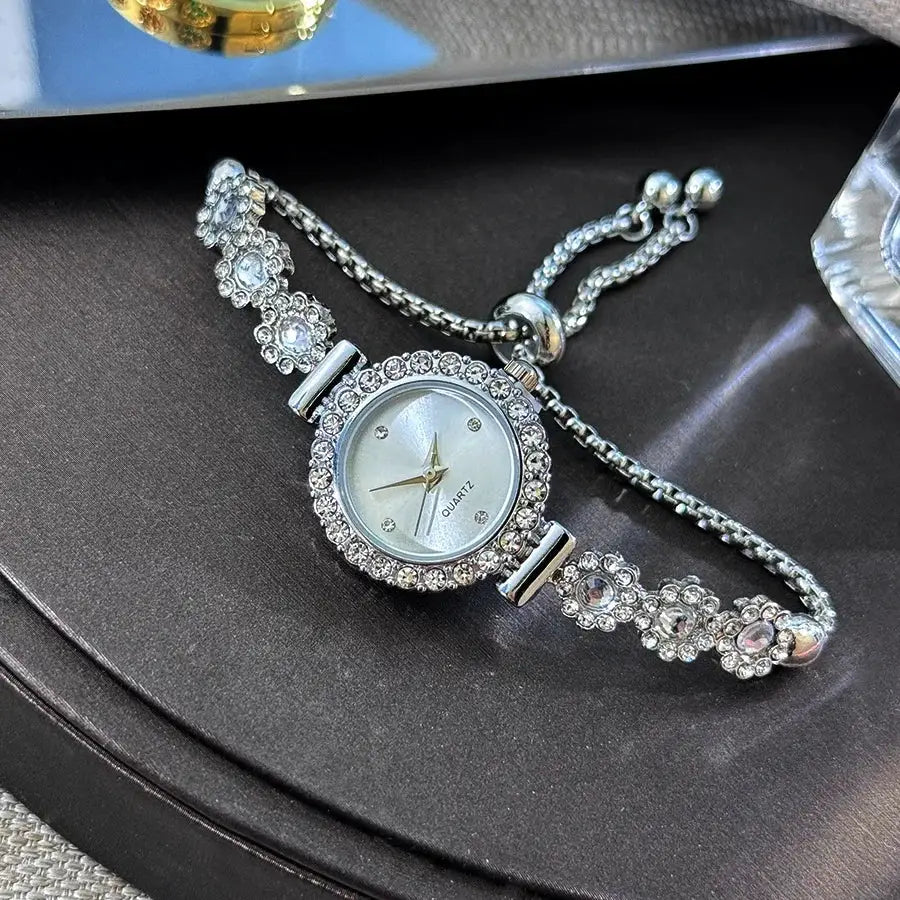 Women's rhinestone bracelet watch with floral crystal accents, silver-tone quartz.
