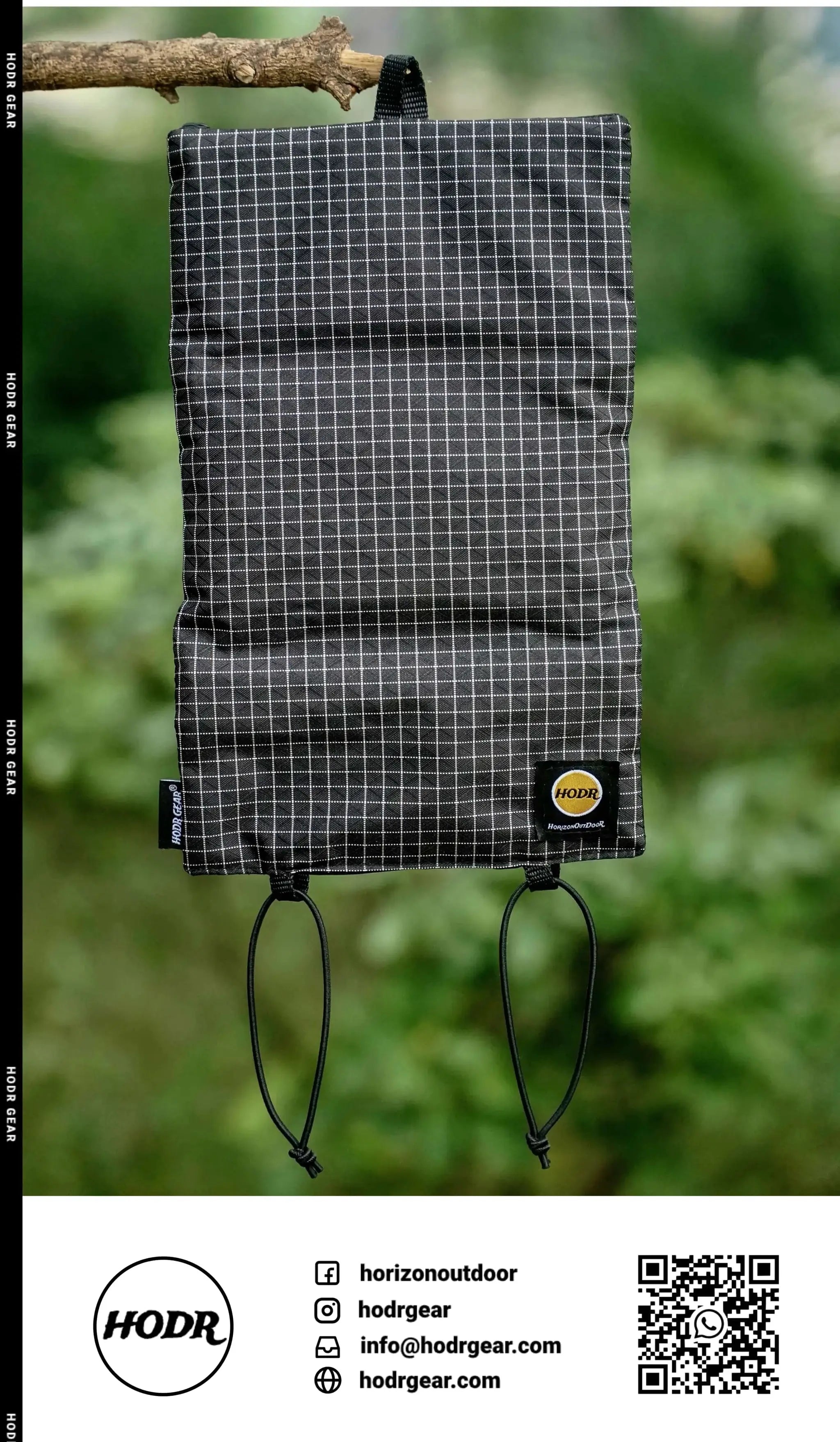 HODRGEAR ultralight toiletries organizer in black grid fabric with drawstrings, hanging outdoors; HODR patch visible.
