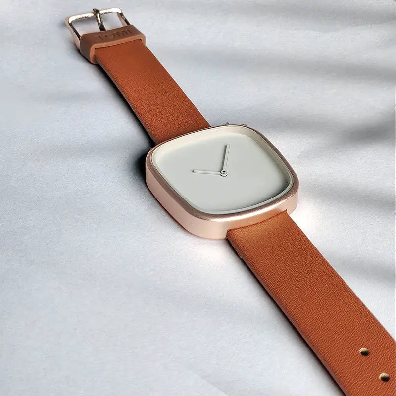 TOMI watch; minimalist square rose-gold case with tan leather strap and white dial