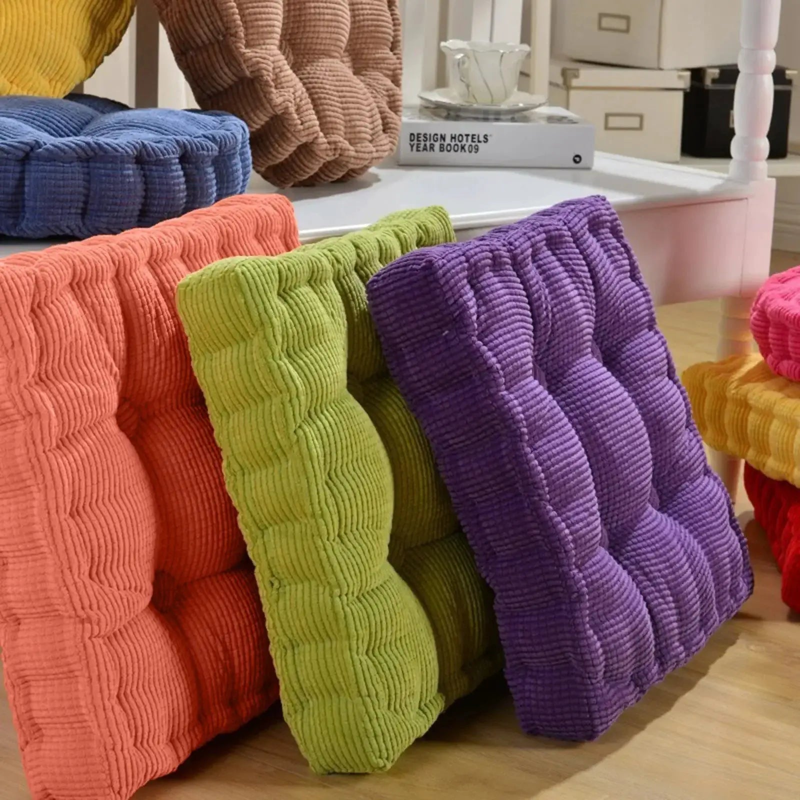 Simples Market thick corduroy square cushions in coral, lime, purple and pink on a wooden floor