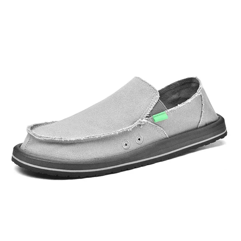 Men's canvas slip-on loafers, low-top in silver-gray with green accent tag and black sole.