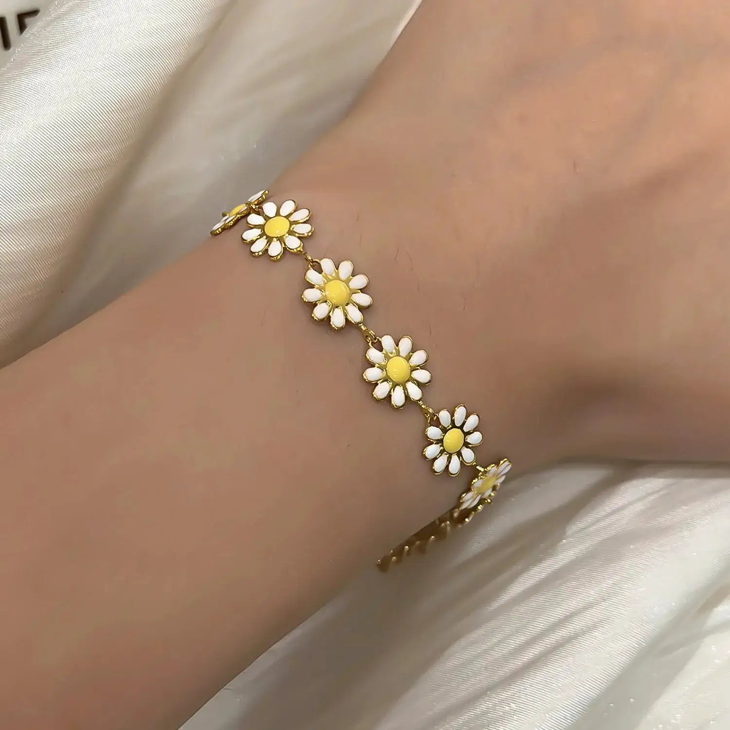 Sweet daisy flower bracelet for women with a gold-tone chain and white petals with yellow centers