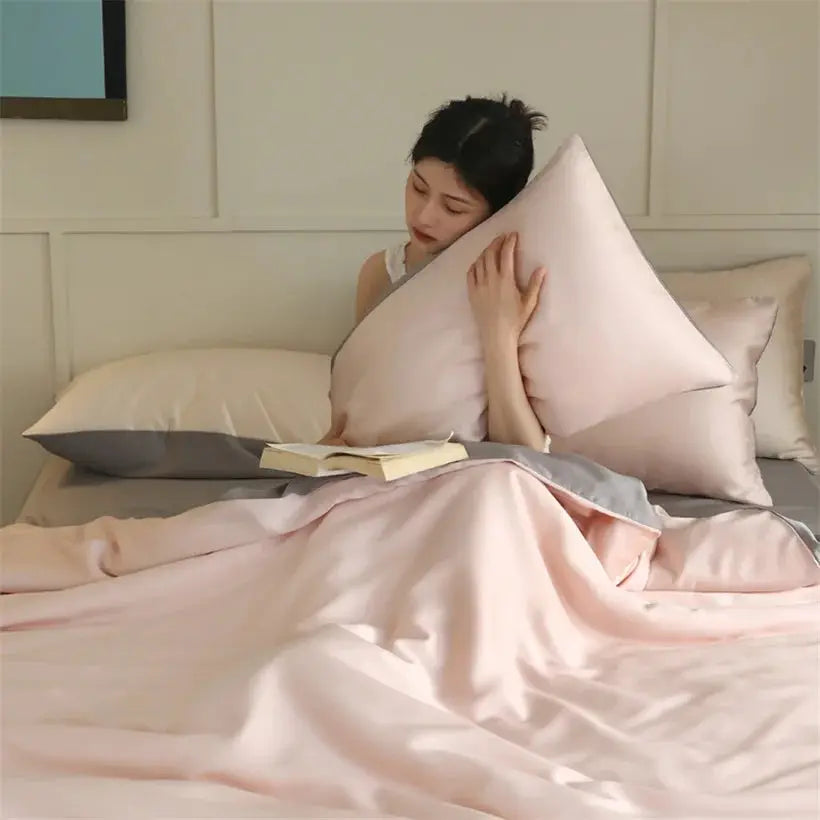 Mulberry silk duvet cover set in pink with matching pillowcases on a bed