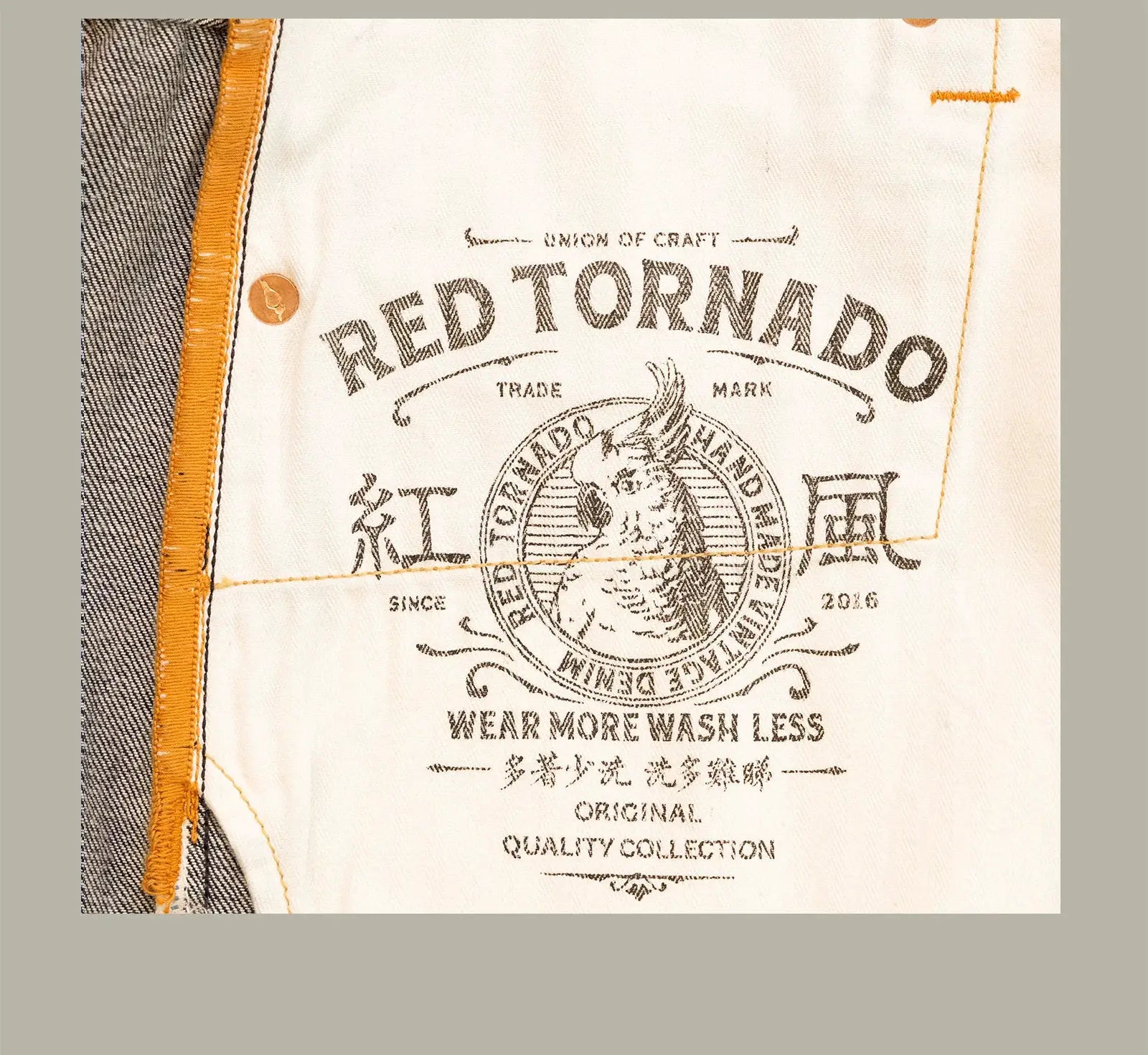 Red Tornado American jeans logo close-up on light denim with orange trim and vintage seal