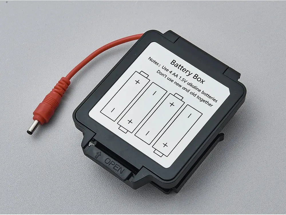 Battery Box, black plastic with red power cable; label shows four AA battery diagram and OPEN latch