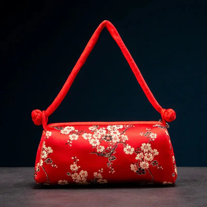Red satin shoulder bag with white floral embroidery, compact purse