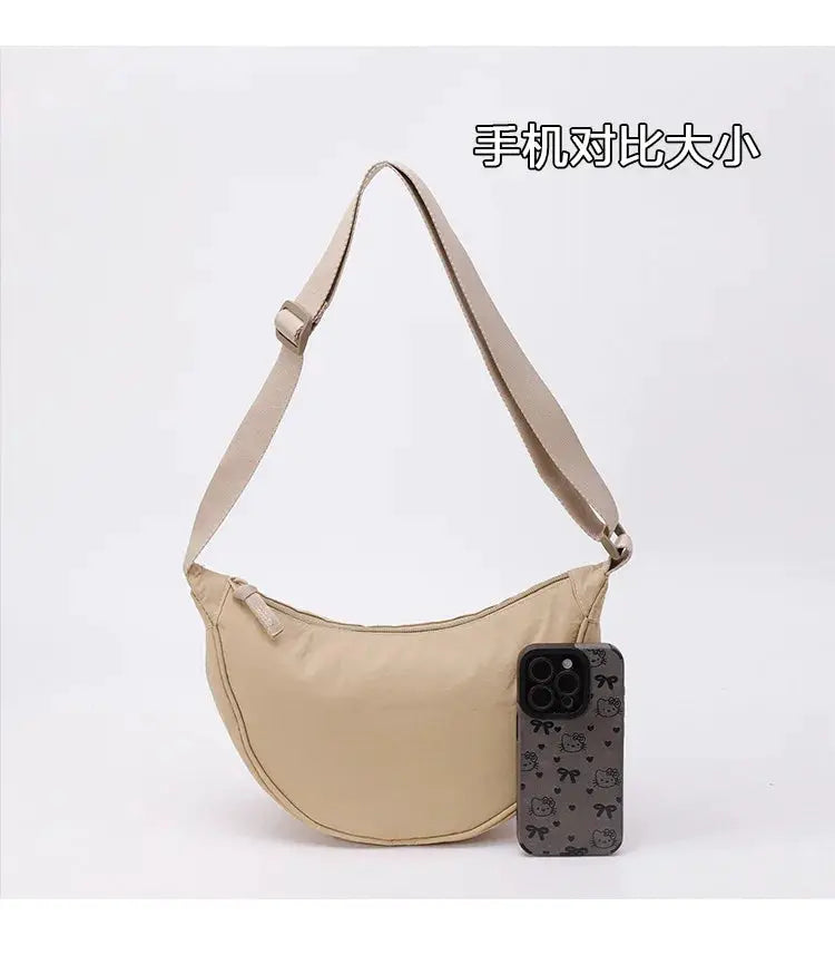 Nylon zipper crescent crossbody bag, beige, with adjustable strap and large capacity.