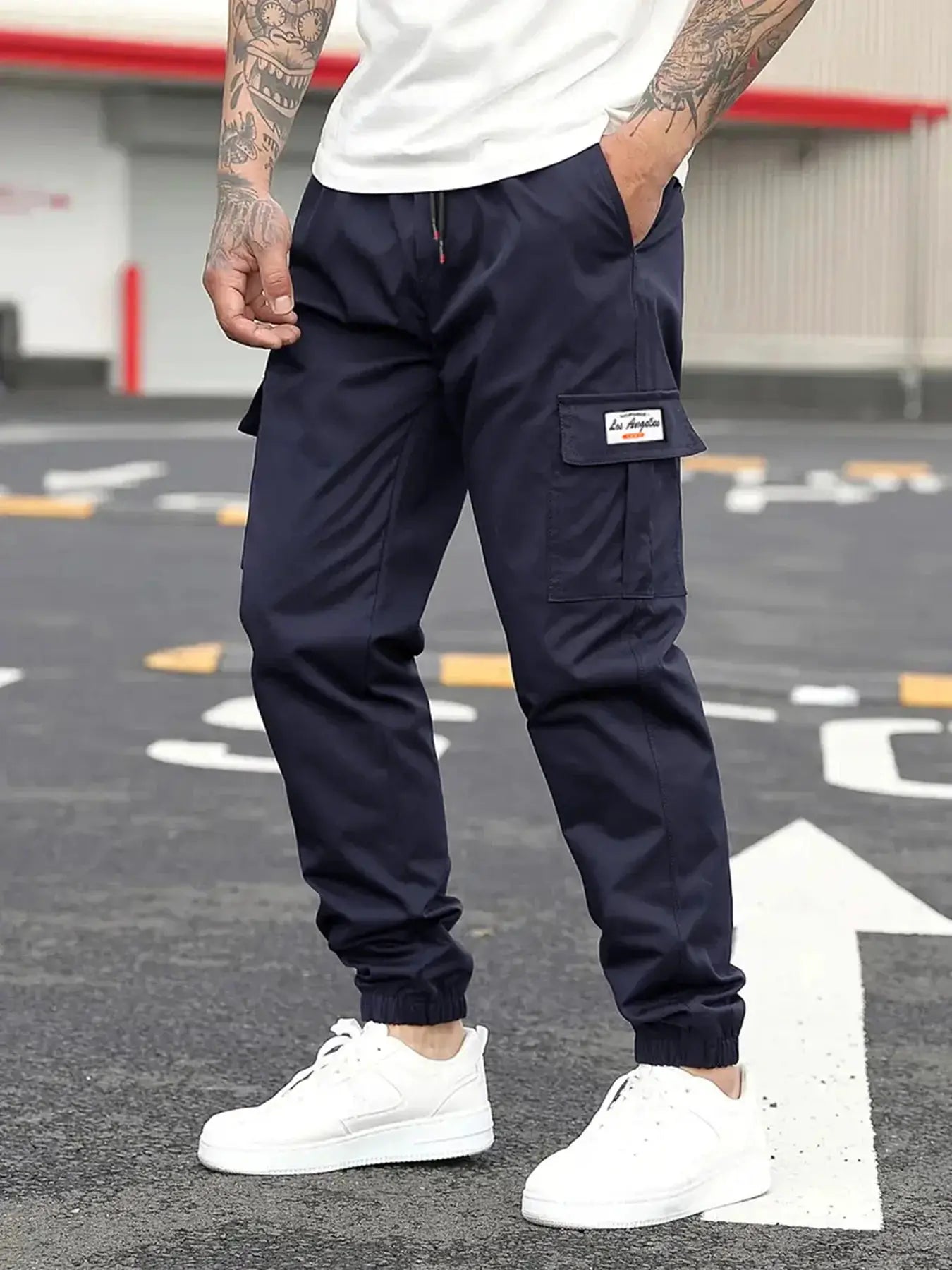 Men's navy cargo jogger pants by Simples Market with drawstring waist, side cargo pocket, and elastic cuffs.