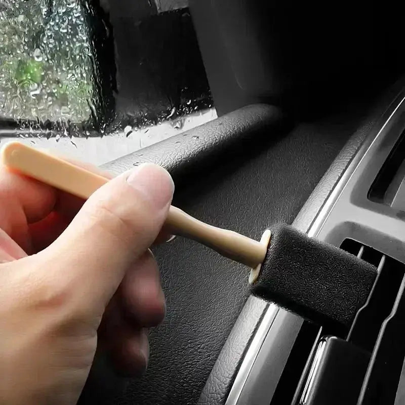 Car AC vent cleaner brush with beige plastic handle and foam scrub head