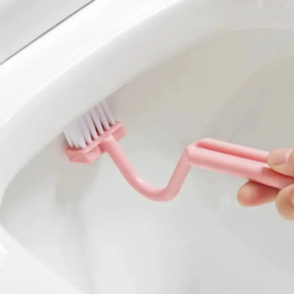 Toilet cleaning brush, pink S-shaped with white bristles and curved handle in a toilet bowl.