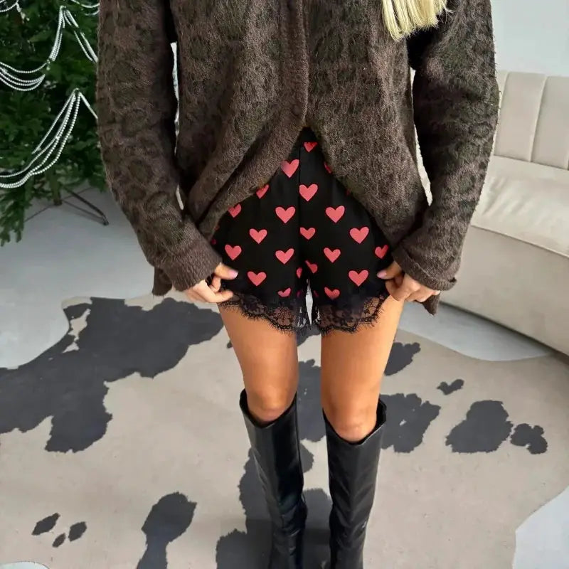 Women heart-print satin lace shorts with elastic waist; pink hearts on black fabric with lace trim