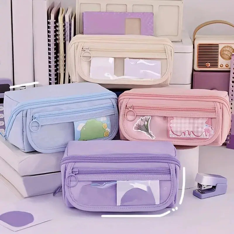 Four pastel pencil cases with zip closures and clear windows in blue, pink, purple and beige