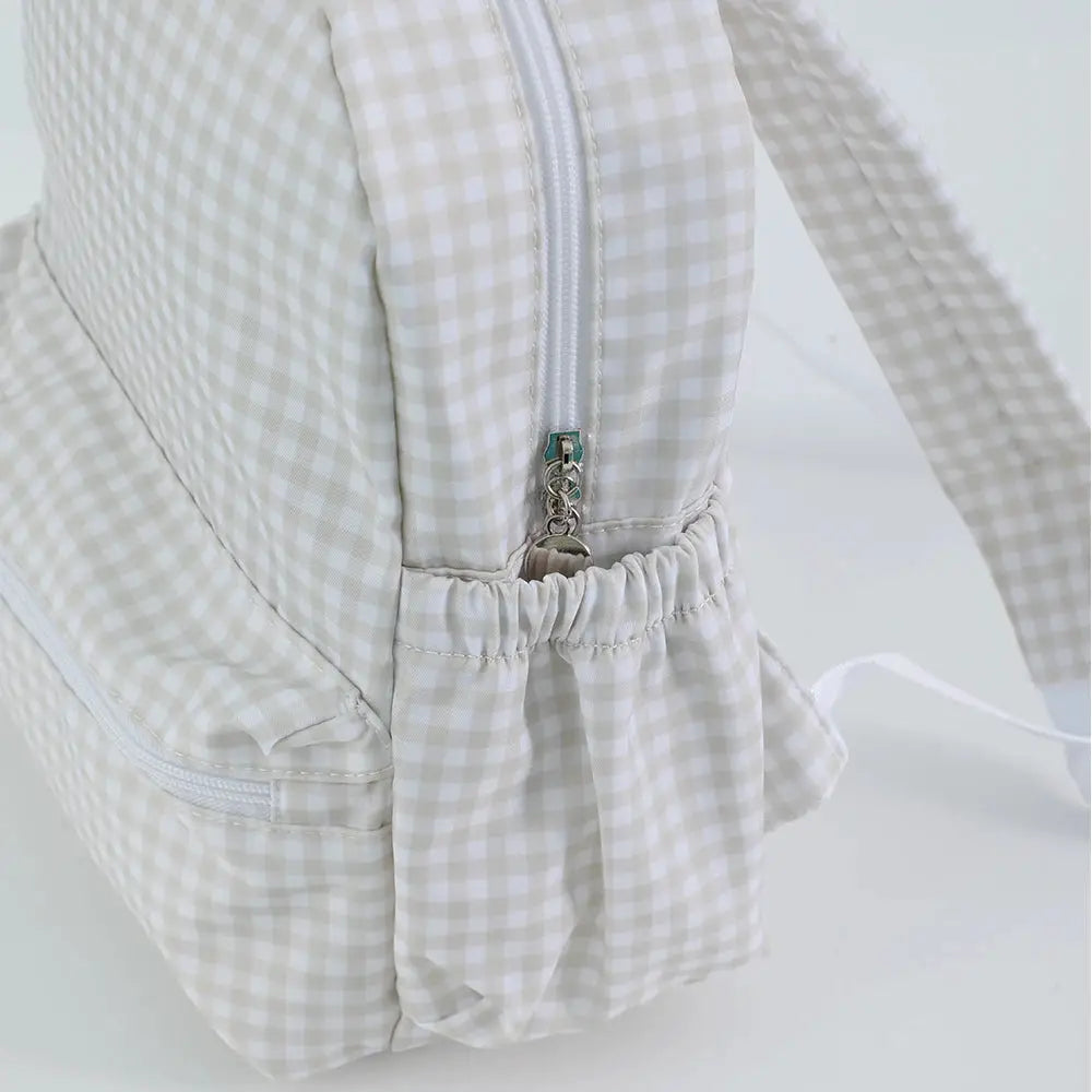 Toddler backpack in beige gingham fabric with zip closure and elastic side pocket